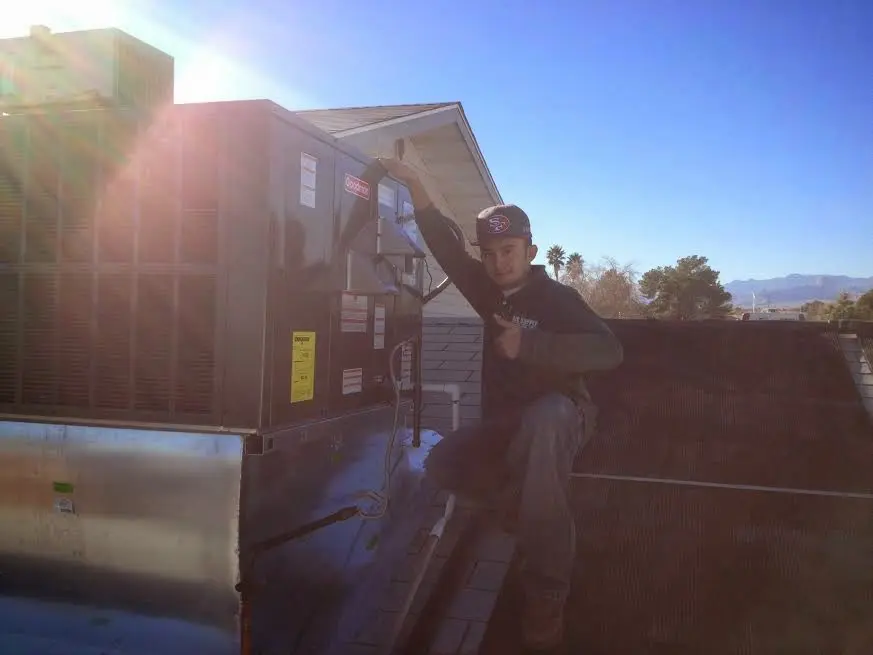 HVAC technician performing HVAC Inspection on a rooftop unit in Concord